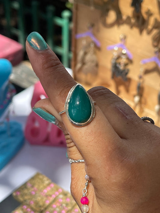 Hand wearing a turquoise ring with a blurred background